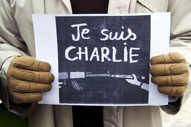 A journalist holds a placard reading in French" I am Charlie" during a gathering on the streets of Pristina on January 8, 2015 in solidarity with the victims of the shooting at the Paris office of the satirical newspaper Charlie Hebdo which left 12 people dead. A stunned and outraged France began a national day of mourning on January 8, as security forces desperately hunted two brothers suspected of gunning down 12 people in an Islamist assault on a satirical weekly, the country’s bloodiest attack in half a century. AFP PHOTO/ ARMEND NIMANI