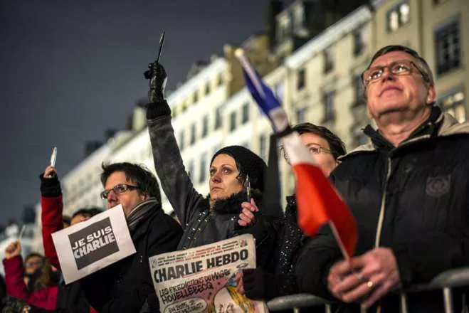 TOPSHOTSA woman cries as she holds up a pen during a vigil in Lyon on January 7, 2015, following an attack by unknown gunmen on the offices of the satirical weekly, Charlie Hebdo in the capital. France’s Muslim leadership sharply condemned the shooting at the Paris satirical weekly that left at least 12 people dead as a "barbaric" attack and an assault on press freedom and democracy. AFP PHOTO / JEFF PACHOUD