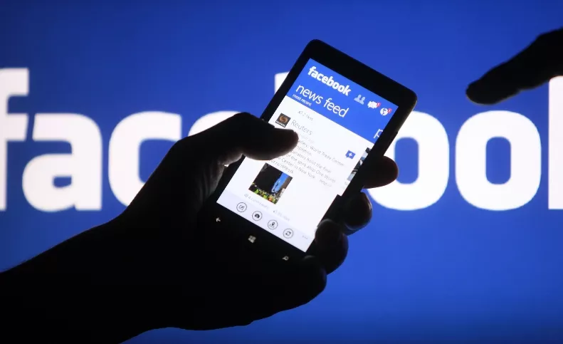 A smartphone user shows the Facebook application on his phone in Zenica, in this photo illustration
