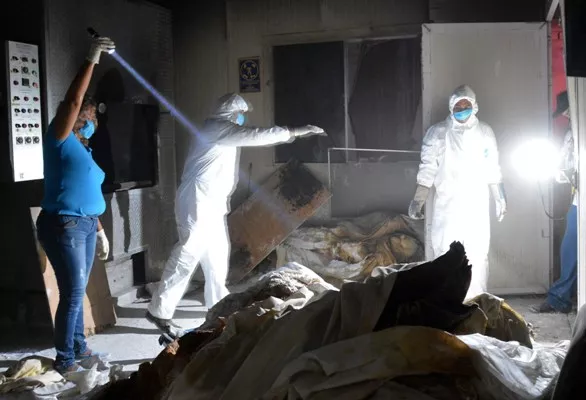 Members of the forensic medical service work at a private crematorium, where ten corpses in an advanced state of decomposition were found in Acapulco, Guerrero State, on February 6, 2015. AFP PHOTO