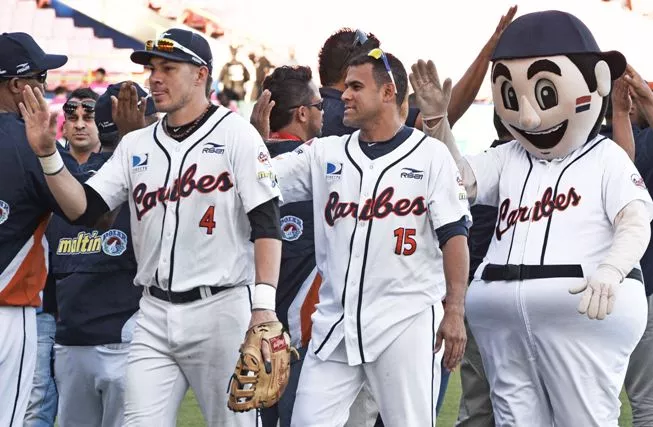 Venezuela National baseball team infielders Niuman Romero (4) and Oscar Salazar(15) share high fives with team mates and followed by the team mascot after defeating the Dominican National baseball team 6-5  at the Serie Del Caribe February 4, 2015, in San Juan, Puerto Rico.    AFP PHOTO/PAUL J. RICHARDS