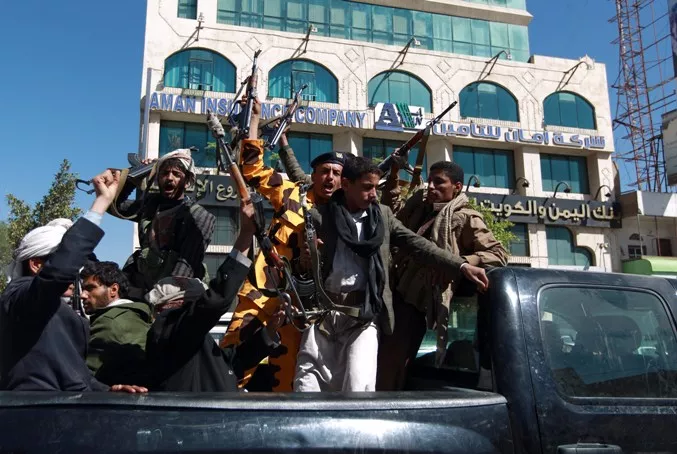 Shiite Huthi fighters shout slogans as they drive in a the back of a vehicle in the Yemeni capital Sanaa on February 11, 2015. Western governments evacuated their diplomats from Yemen on Wednesday as conflict deepened in the impoverished Saudi neighbour which has long been on the front line of the war against Al-Qaeda. AFP PHOTO / MOHAMMED HUWAIS