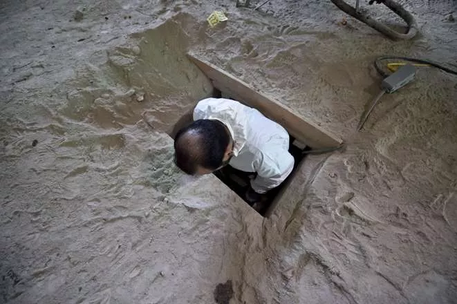 An investigator inspects the alleged tunnel through which Mexican drug lord Joaquin "El Chapo" Guzman might have escaped from the Altiplano prison ended, in Almoloya de Juarez, Mexico, on July 15, 2015. Drug kingpin "El Chapo" Guzman escaped in July 11 through a 1.5-kilometer (one-mile) long tunnel that was dug under the shower space of his prison cell in central Mexico, authorities said Sunday. Guzman paced nervously in his cell before bending down behind his shower’s short wall and vanishing, according to newly released security footage of his daring jailbreak.  AFP PHOTO / YURI CORTEZ