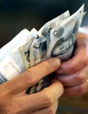 A vendor gives change of 10 Yuan notes to a customer in Beijing