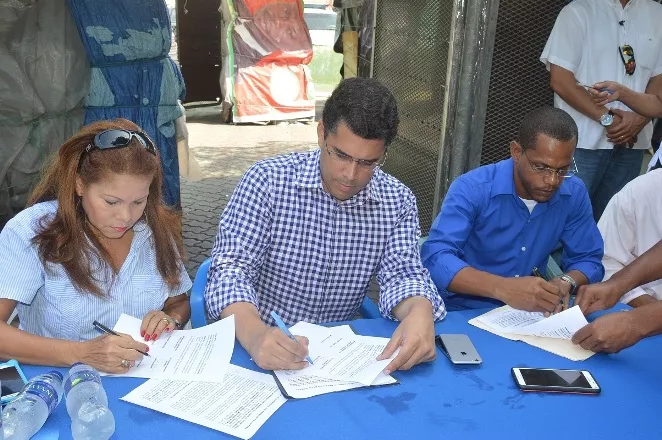 David Collado firma el acuerdo junto a Digna Reynoso y Maricio Collado