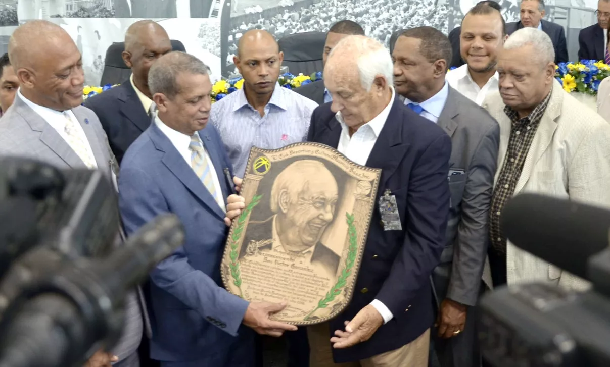 La directiva del club Mauricio Báez le entrega la placa a Víctor González por la dedicatoria del Desayuno de la Confraternidad con motivo del 53 aniversario de la entidad deportiva. José de Leon