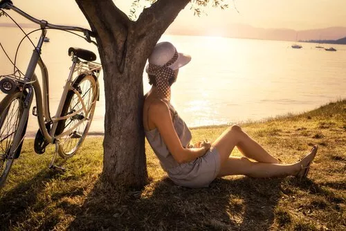 mujer-solitaria-sentada-en-el-suelo-mirando-al-lago-500×334