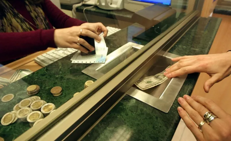 A civilian buys dollar at a currency exchange hous