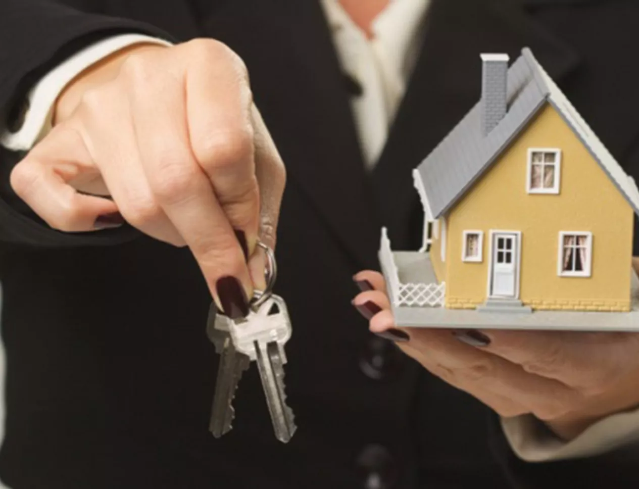 Female presenting keys and small house.