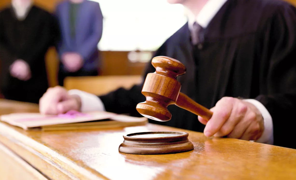 Judge holding gavel in courtroom