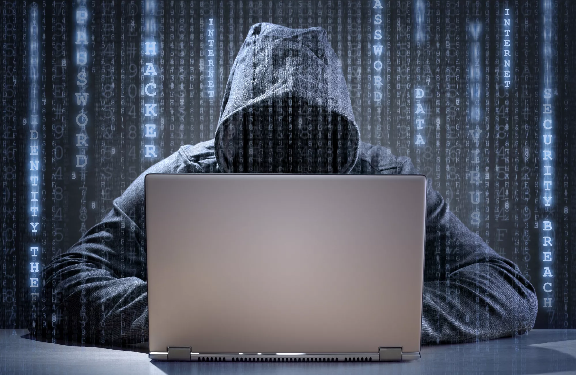 Computer hacker stealing data from a laptop
