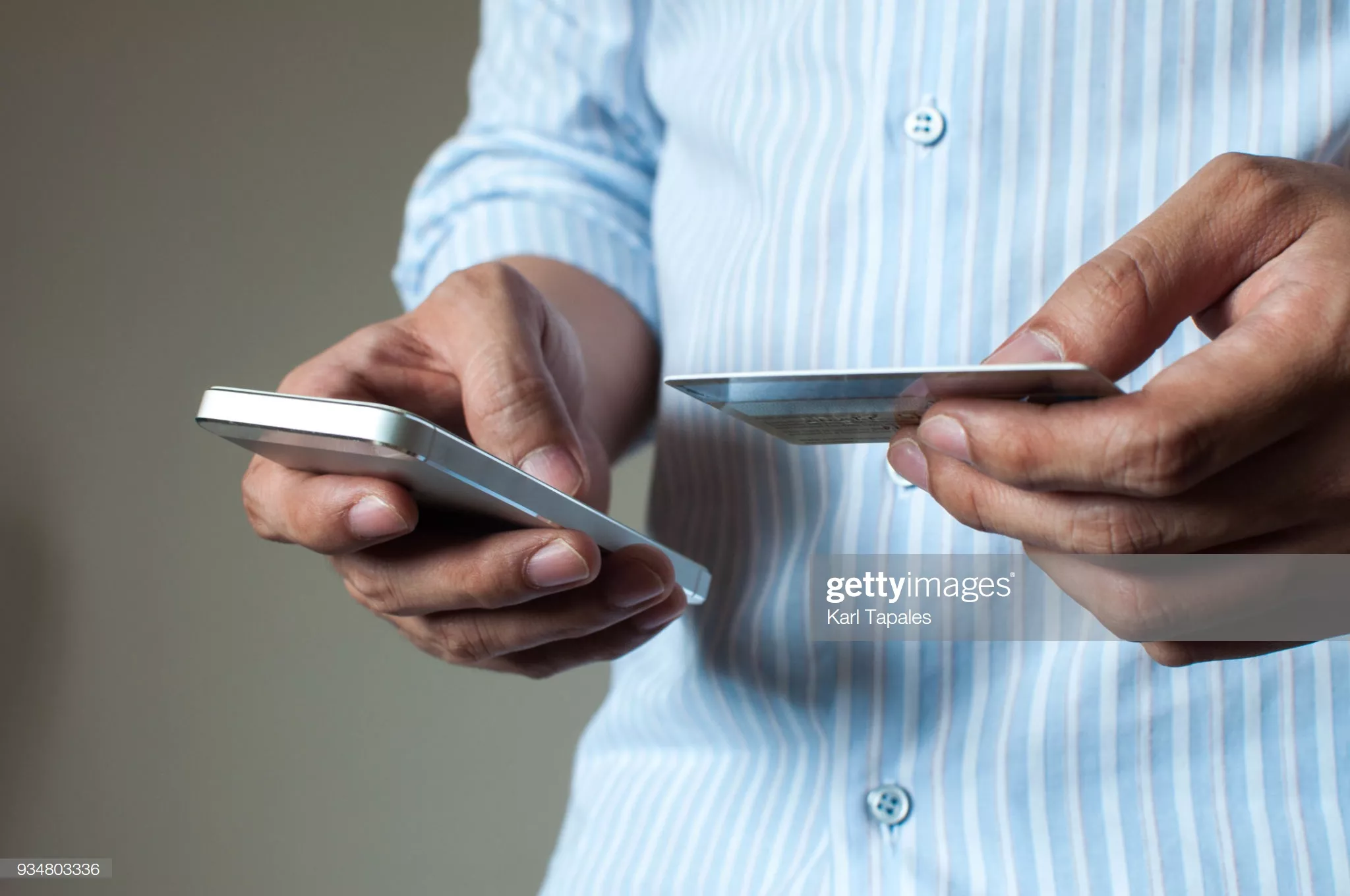 A businessman is buying online using his mobile phone and credit card