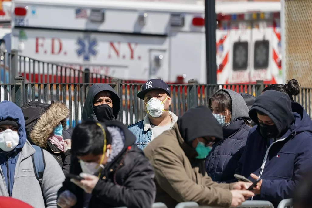 People wait on line to receive a Coronavirus test at Elmhurst Hospital in the Borough of Queens