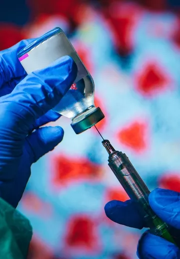 Coronavirus Covid-19 Protection and Vaccine. Doctor drawing up solution from vaccine bottle and filling syringe injection for patient vaccination in medical clinic, Coronavirus in background