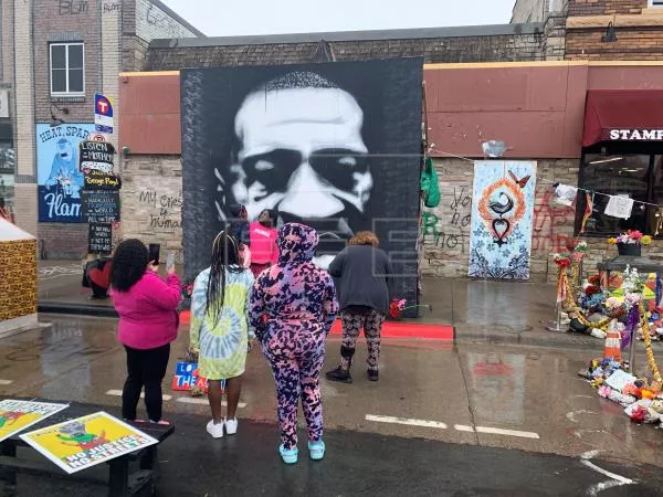 Residentes del barrio Powderhorn Park fueron registrados este sábado al rendirle un homenaje al afroamericano George Floyd, en la esquina en la que murió asfixiado por un exagente de policía, previo a que se inicien los argumentos orales del juicio, en Mineápolis (Minesota, EE.UU).