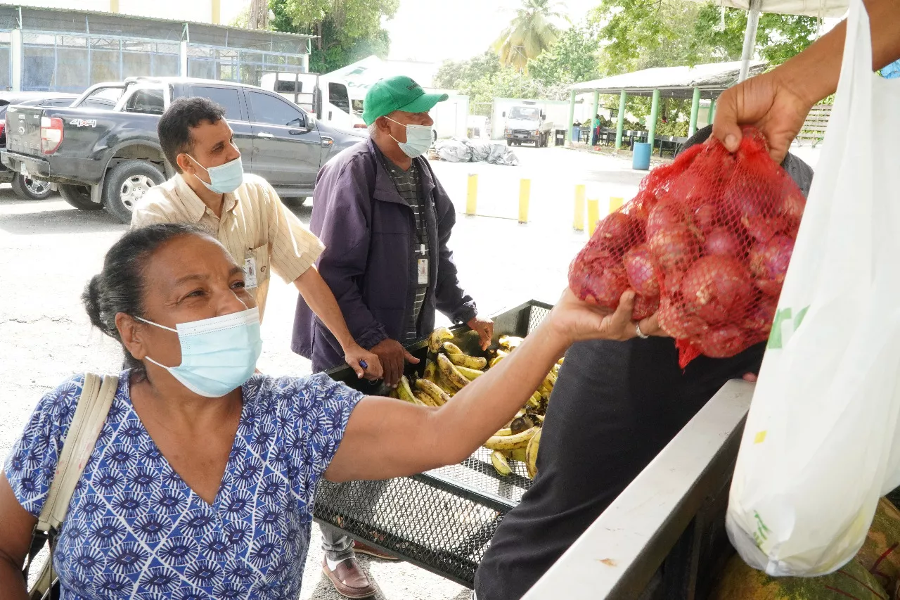 Una señora compra en mercados Inespre cebollas rojas criollas