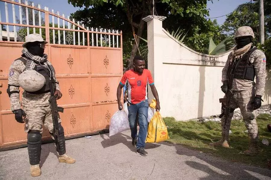 Personas sale con ayuda humanitaria entregada por una entidad privada en las afueras de Les Cayes (EFE)