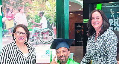 Ejecutivas de la fundación junto a un graduando.