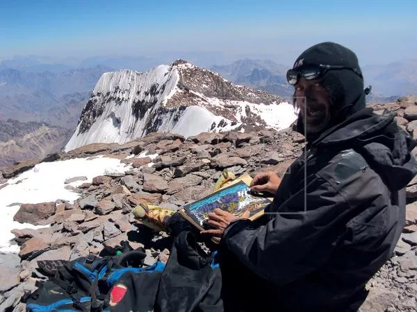 Fotografía de Archivo Personal, cedida por el artista Miguel Doura, donde se le ve sobre un cerro mientras pinta, en el Aconcagua. EFE/ Miguel Doura