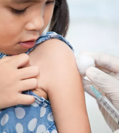 Doctor injecting vaccination in arm of asian little child girl
