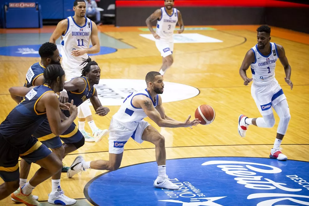 Mike Torres busca pasarle el balón a Juan Miguel Suero, del equipo dominicano, en el partido ante Islas Vírgenes.
