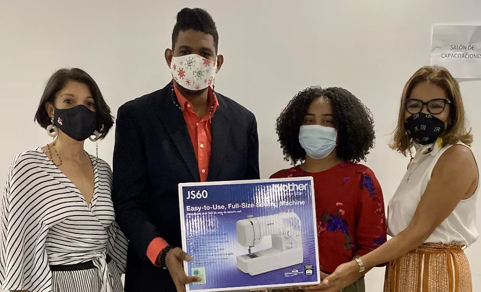 Los jóvenes reciben la máquina de coser.