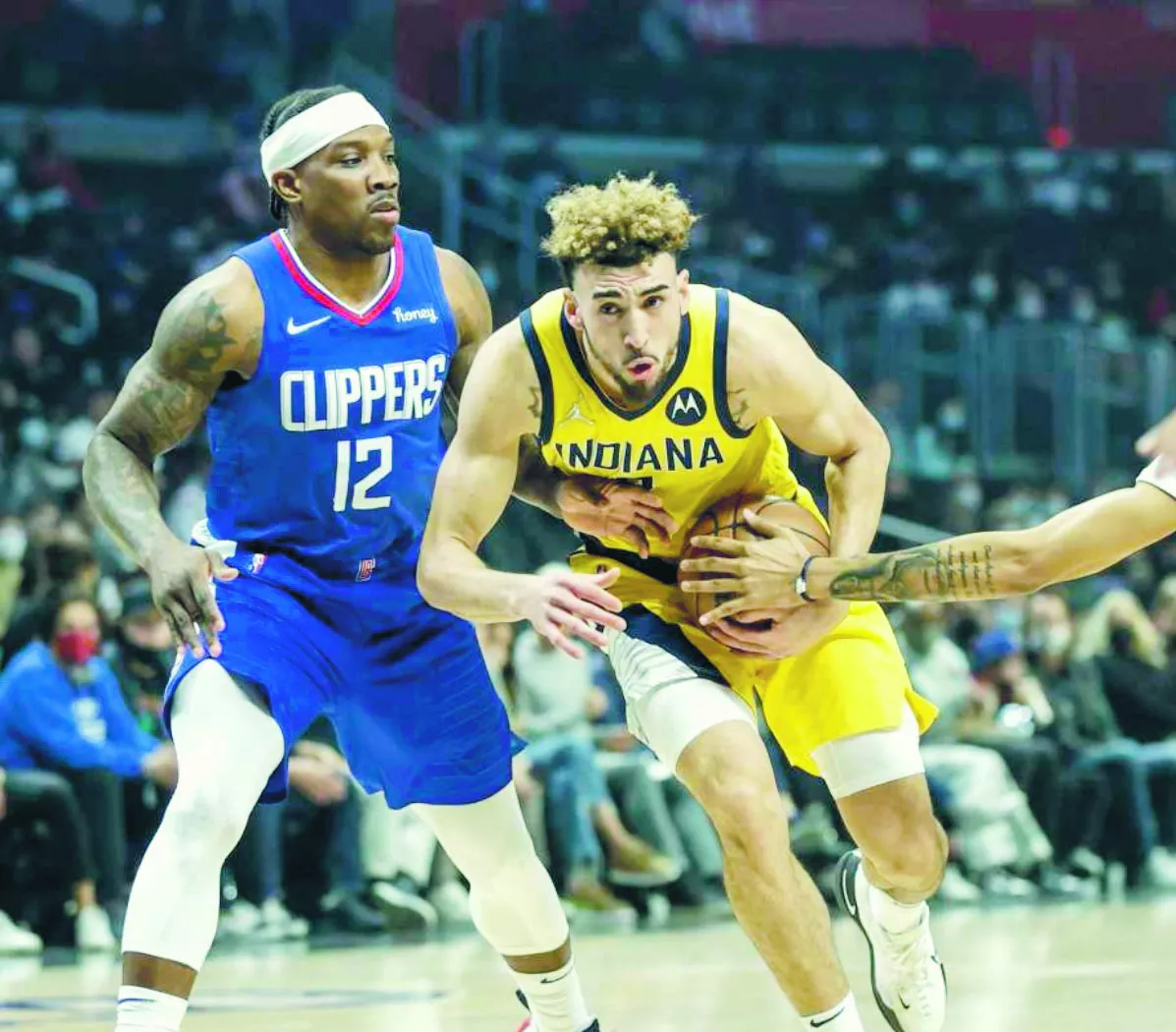 Chris Duarte intentaburlar la denfesa del jugador de los Clippers,   Eric Bledsoe.  Ap