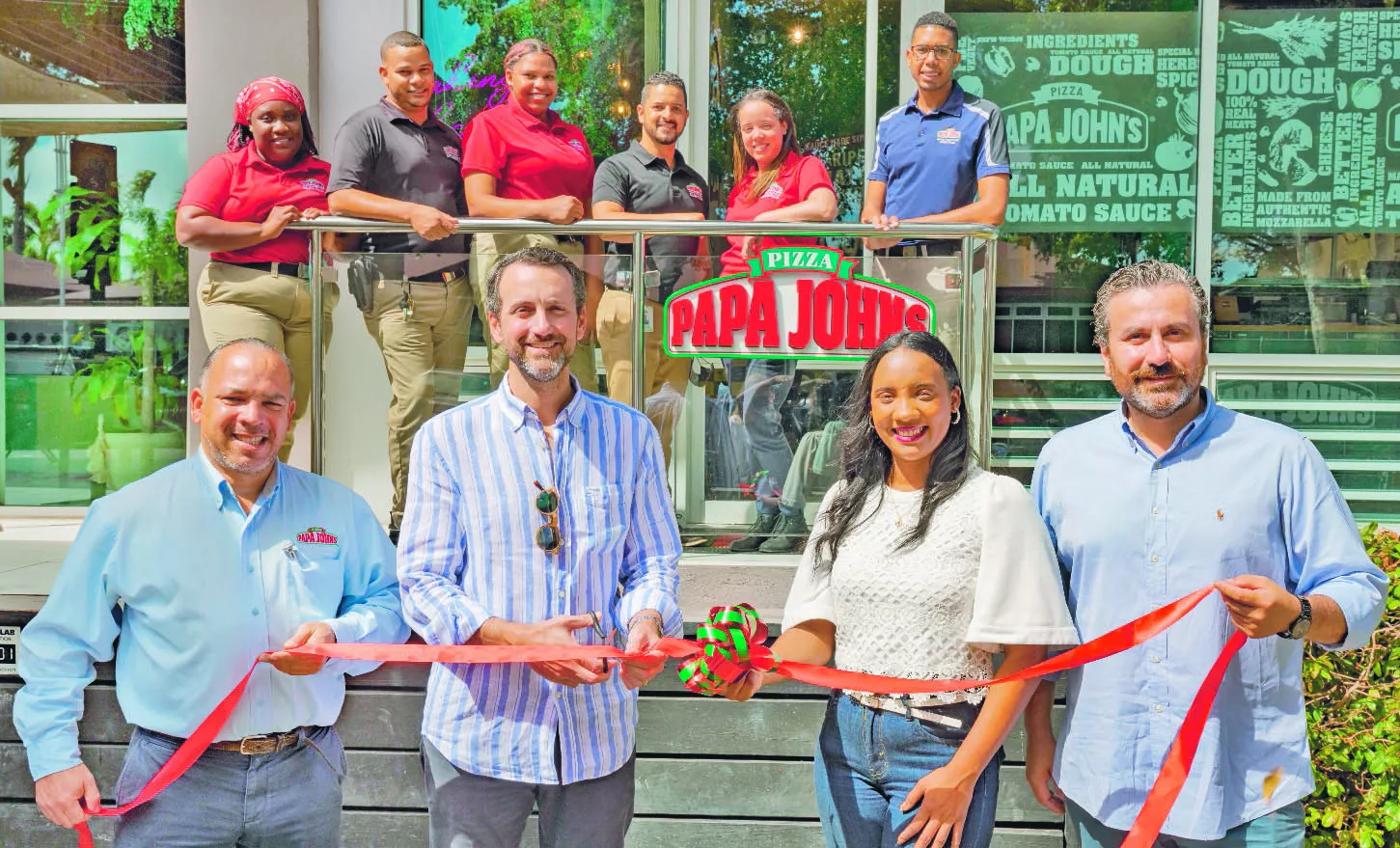 Máximo Rosario, Marcos Sánchez, Yohanny Mora y Osvaldo Sazo, junto  al personal de servicio de la sucursal número 19 de  Papa John’s, en la Plaza Paseo San Juan, Bávaro Punta Cana.