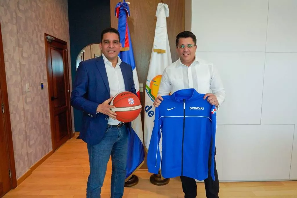 Rafael Uribe, presidente de Fedombal, entrega souvenirs de baloncesto al ministro de Turismo, David Collado.