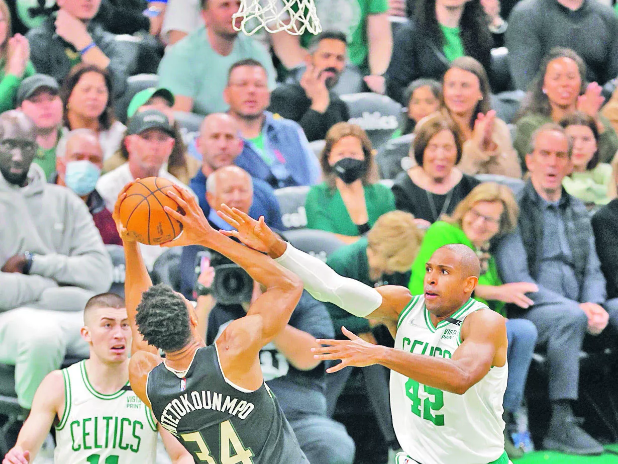 Giannis Antetokounmpo  intenta realizar un lance ante la defensa de Al Horford.  efe