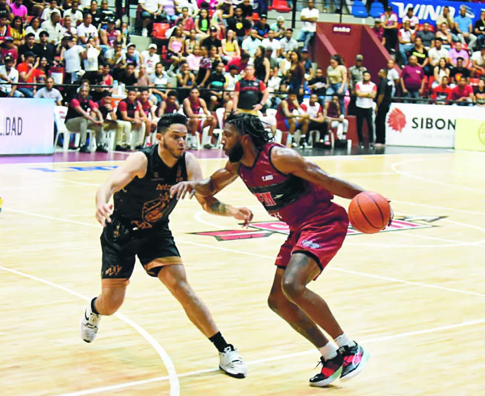 Pe’Shon Howard  intenta burlar la defensa de   Eddy Polanco durante el quinto partido de la serie final ante Leones.