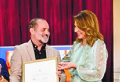 Milagros Germán entrega un pergamino a hijo de Lebrón.