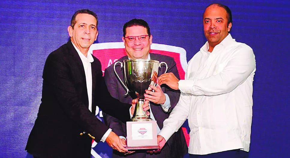 Samuel Pereyra entrega a Eduardo Sanz Lovatón y  Diego Pesqueira la Copa Banreservas  en disputa en  torneo.  carlos alonzo