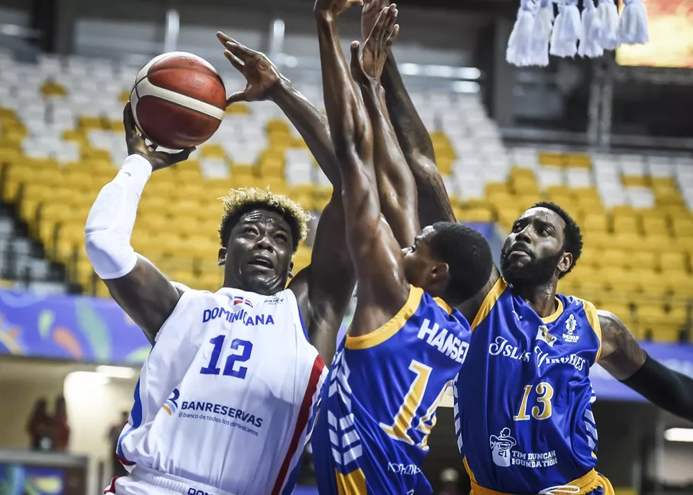El dominicano Ángel Luis Delgado en una ofensiva sobre los jugadores de Islas Vírgenes, Romani Hansen (14) y Rakeem Christmas (13).