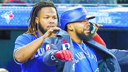 Vladimir Guerrero le pone el jacket a Teóscar Hernández.