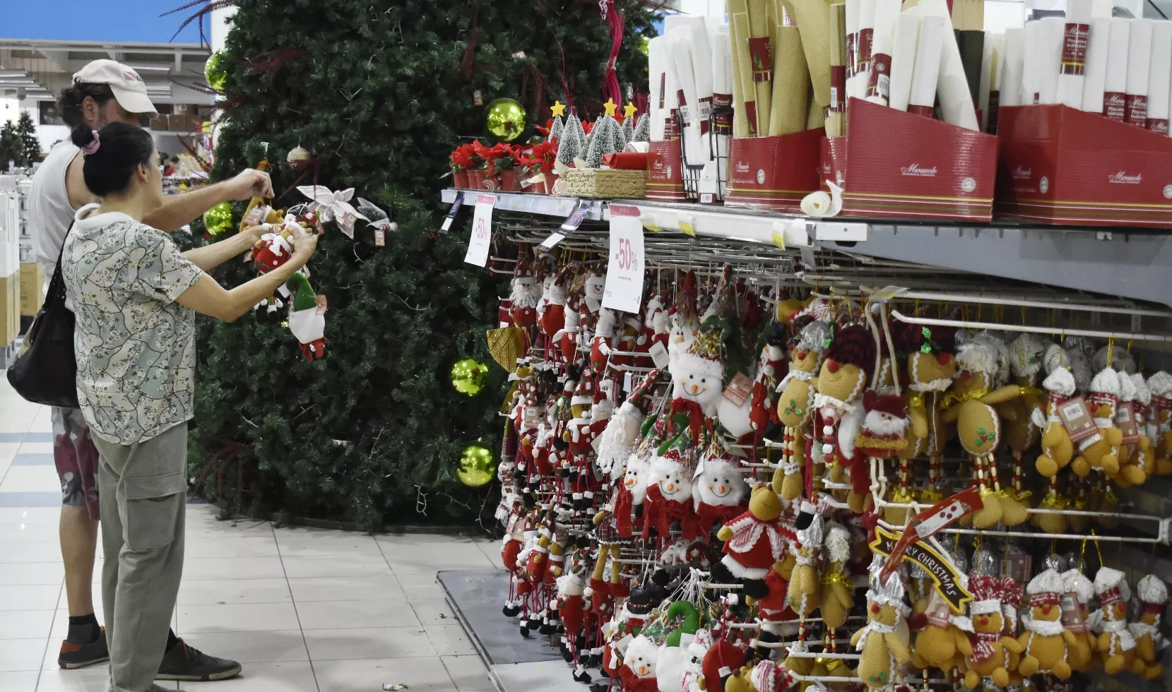 Una pareja evalúa cual artículo navideño va acorde con la decoración que tienen en su hogar.   josé de león