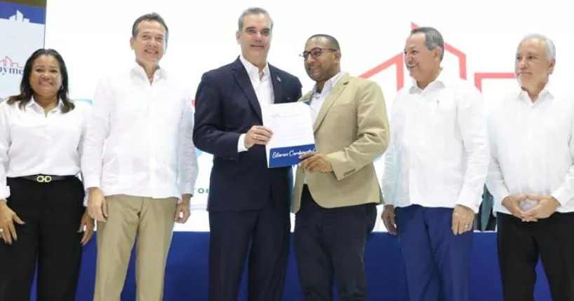 Abinader  entregando préstamo a un pequeño empresario.