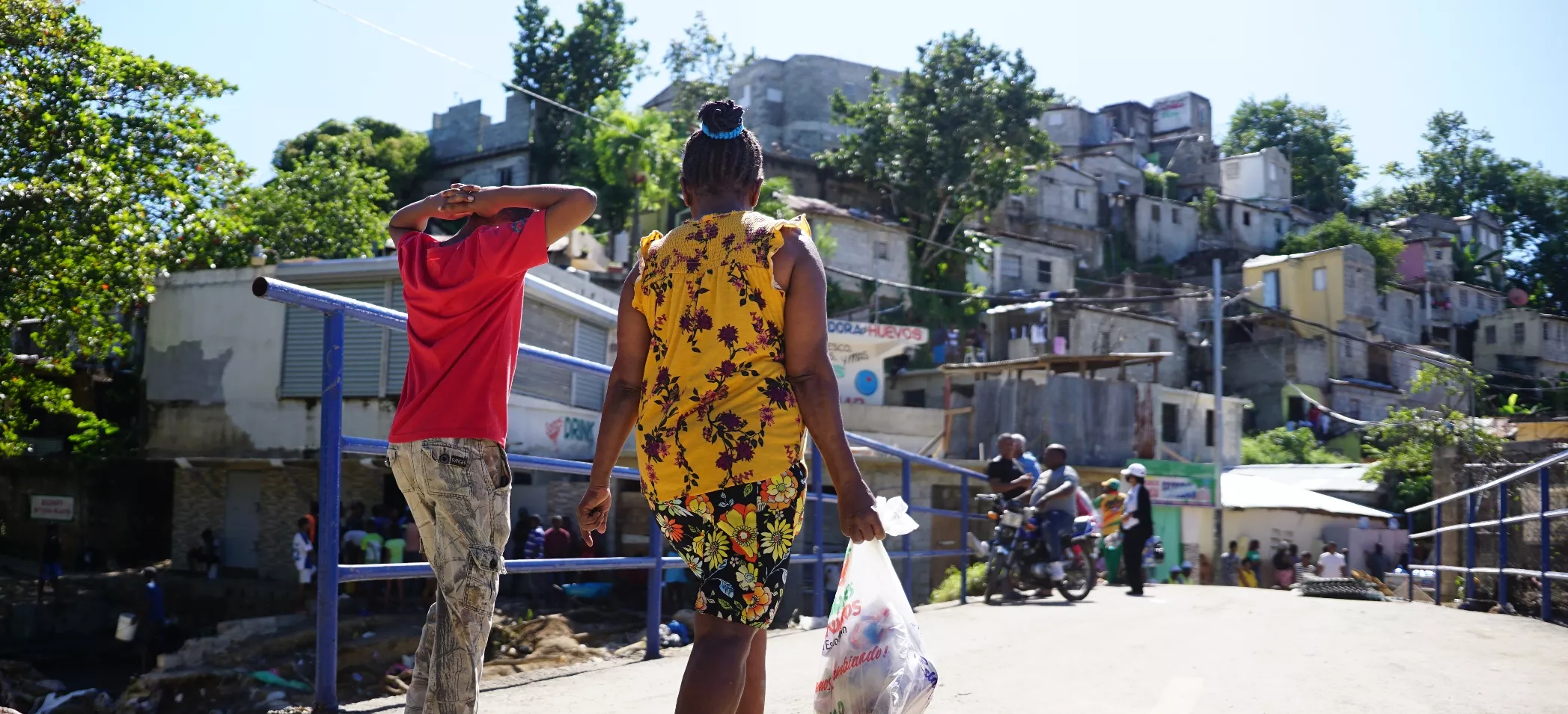 Flora Valdez, luego de  buscar medicamentos y  ración alimenticia se dirige con su hijo a lo que quedó de su hogar por  las inclemencias del tiempo.  Elieser tapia