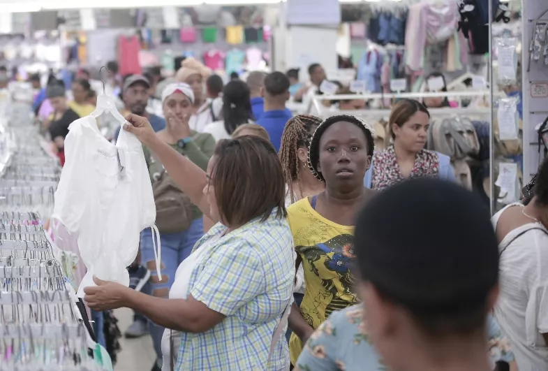 Una mujer mientras mira una blusa.  elieser tapia