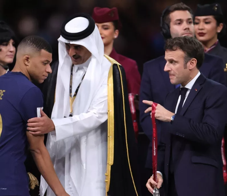 El presidente Enmmauel Macrón  premia a Kylian Mbappé.