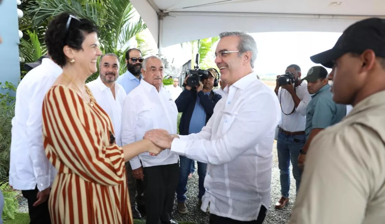 Amelia Vicini saluda al presidente Abinader. Les observan Juan Vicini y Carlos Martí.