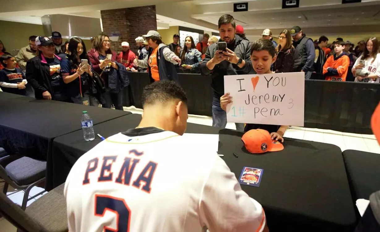 El dominicano Jeremy Peña firma autógrafo a un niño con un cartel que dice que lo ama.  Ap