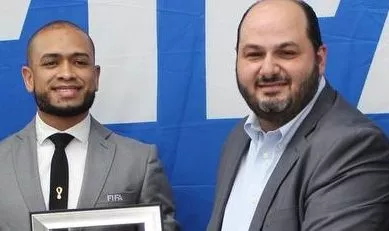 Raymundo Feliz (izq) recibe su gafete y reconocimiento.