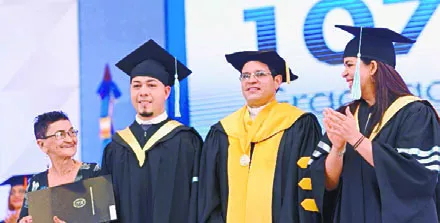 Secilio Espinal, rector  de la PUCMM, junto a directivos y uno de los graduandos.