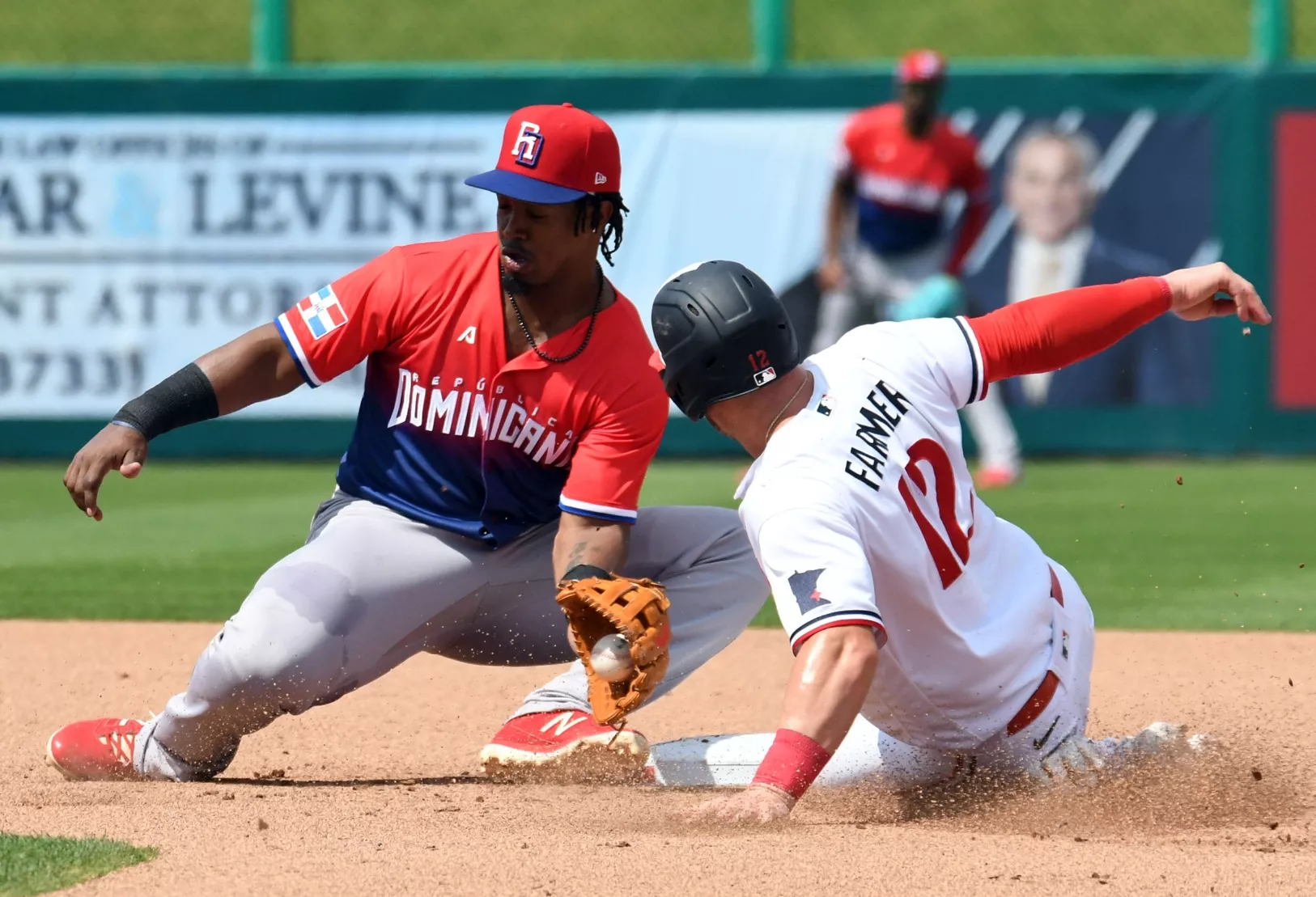 Jean Segura intenta poner fuera a Kyle Farmer de los Mellizos durante la acción del partido en Fort Mayers.   Alberto calvo