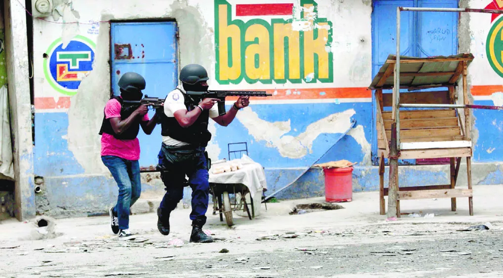 Agentes de  la policía se refugian durante una operación antipandillas en el barrio Portail de Puerto Príncipe, Haití.ap