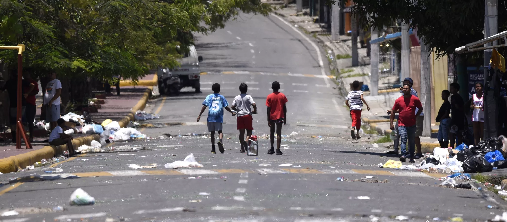 Personas mientras caminan en las  calles en Navarrete,  donde se registraron disturbios y lanzamiento de desperdicios.     EFE
