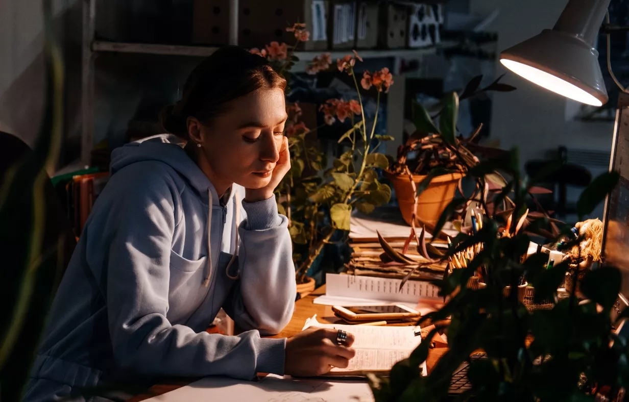 Worker burnout, hours overtime, emotional burnout, Mental health problem. Tired businesswoman, worker sitting in office near desktop with computer in evening. Long working day in office