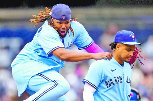 Vladimir Guerrero Jr. celebra con  alegría a  Santiago Espinal.