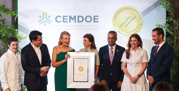 Raquel Peña, entrega la certificación a los ejecutivos.